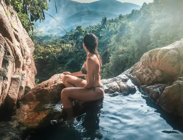 Una mujer sentada en una poza de la selva en Costa Rica